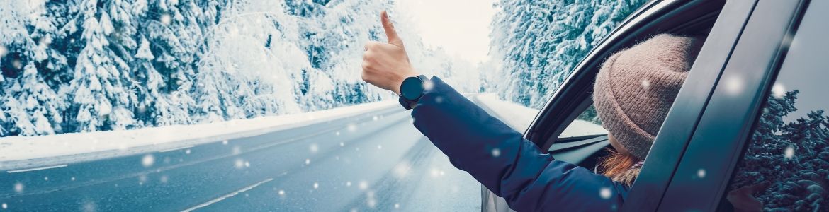 happy woman gesturing in car on snowy road